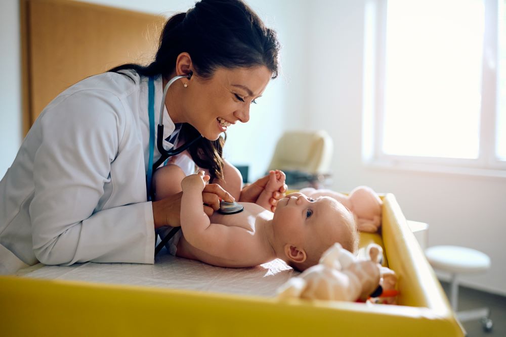 A pediatrician examining her newborn patient's heartbeat.