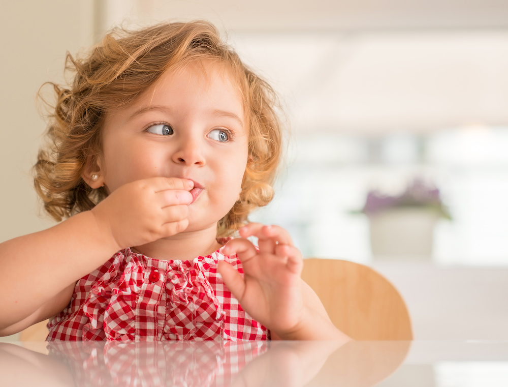 child with asthma eating chocolate at the dinner table